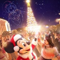 Mickey in a Santa hat in front of the Christmas tree on Main Street, U.S.A. at Hong Kong Disneyland